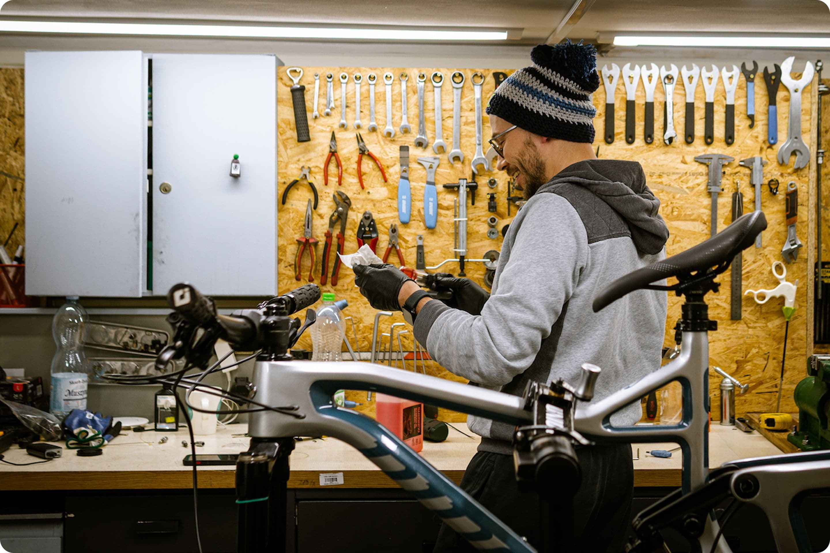Zdjęcie przedstawia mechanika z Serwisu Rowerów Drogich we Wrocławiu podczas naprawy roweru.