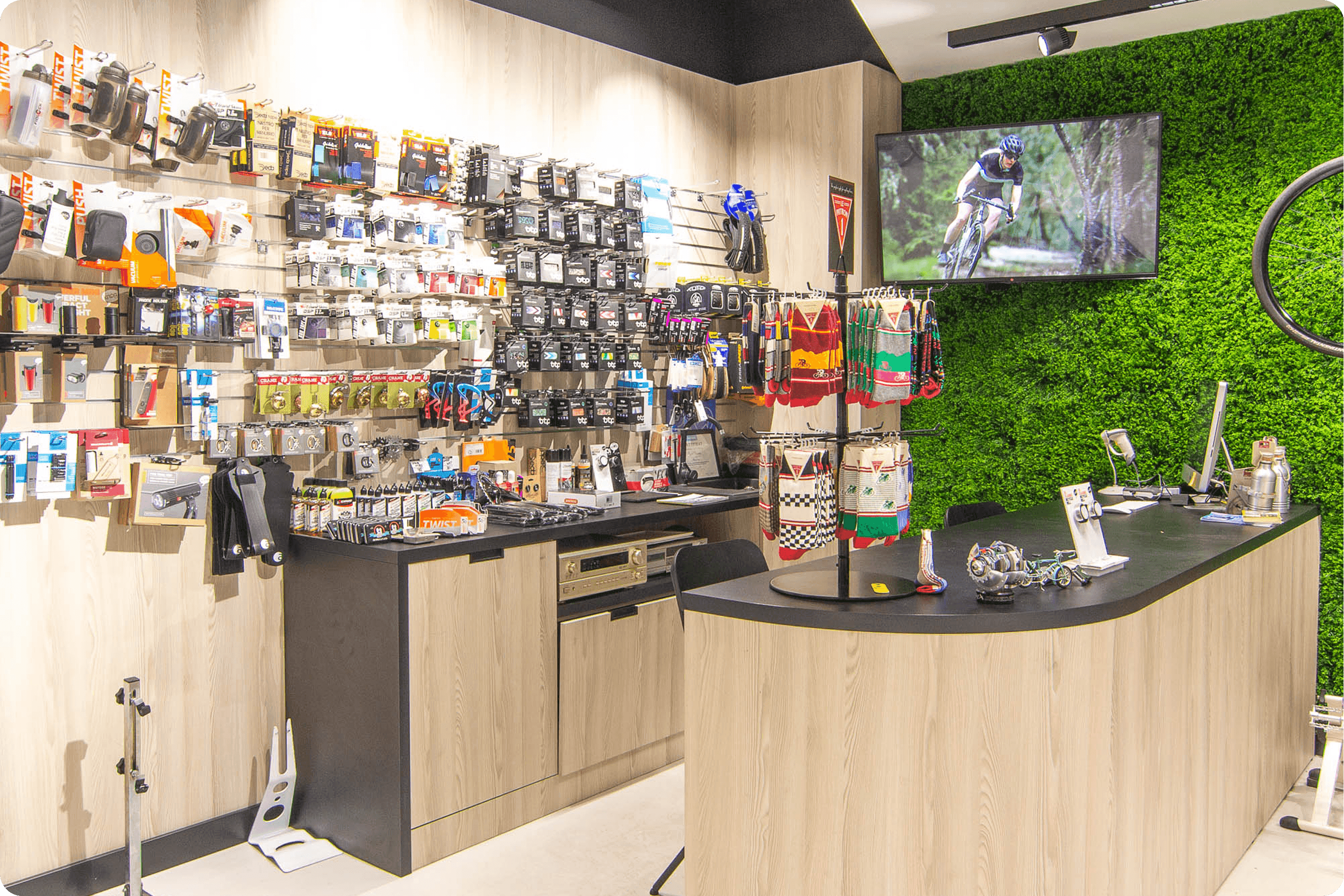 Zdjęcie wnętrza serwisu rowerowe Antymateria w Warszawie przedstawiające ladę i ścianę z produktami.